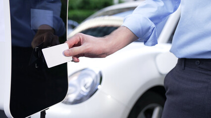 A man use his credit card to pay for eco-friendly clean and sustainable energy for his electric...
