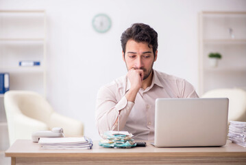 Naklejka premium Young male accountant working in the office