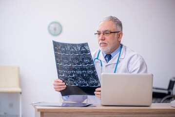 Old male doctor radiologist working in the clinic
