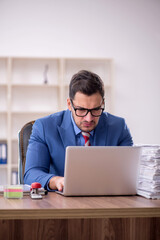 Young male employee unhappy with excessive work in the office