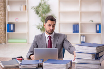 Young male employee and too much work in the office