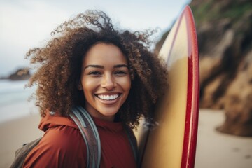 Smiling portrait of a happy female african american surfer on a beach in California - obrazy, fototapety, plakaty