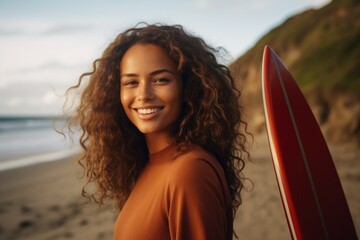 Smiling portrait of a happy female african american surfer on a beach in California