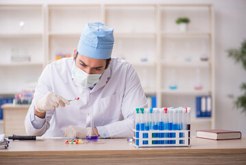 Young male chemist working at the lab