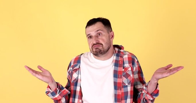 Confused man, shoulders up - can't help, makes gesture of I don't know.