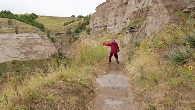 senior male hiker at the Saddle Rock Trail leading to the summit of Scotts Bluff National Monument in late summer scenery