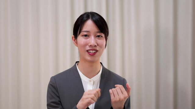 ジェスチャーを交えて話をするスーツ姿のビジネスウーマンのフロントショット