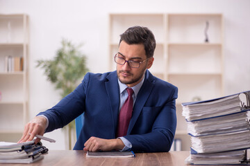 Young male employee and too much work in the office