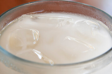 Fototapeta na wymiar Close up ice cubes in glass of horchata rice beverage