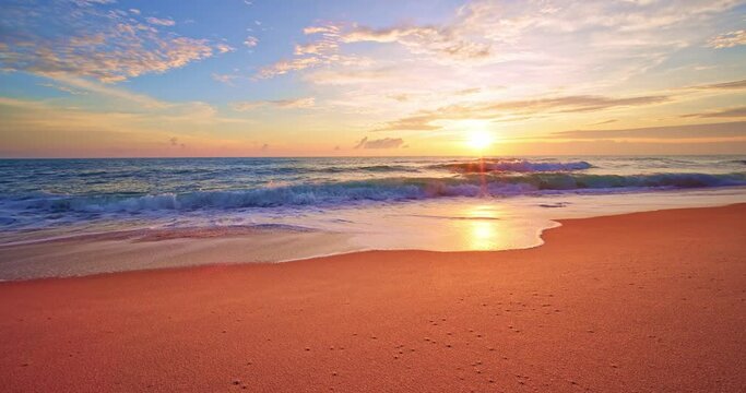 Colorful ocean beach at sunrise or sunset sky over sea,Beautiful waves crashing on pink sandy shore in summer season,Slow motion waves sea beach background