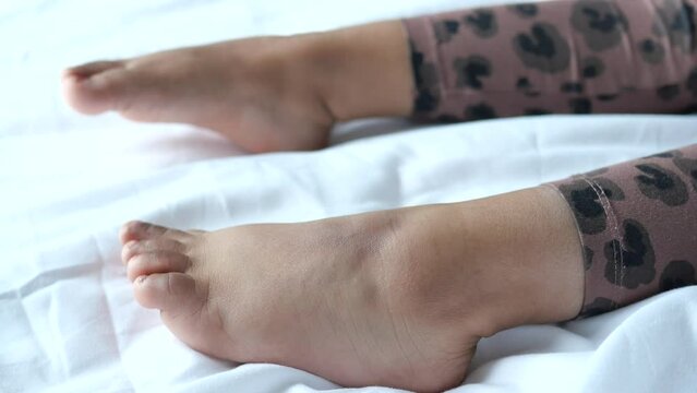 5 year old child girl feet on bed close up