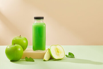 Green apple cut in half decorated with a bottle containing green juice. Green Apple (Malus domestica) is packed with beneficial nutrients, proteins, fiber, and minerals