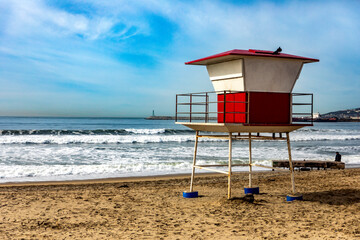 Golden sand beach with the guard station of the beach guards in Ensenada under a blue sky in the state of Baja California in Mexico, this is a place very visited by tourists and bathers in summer.