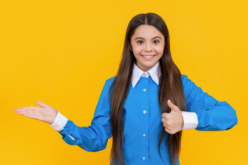 teen student has happy face. offer and presenting product. teen school girl in uniform making...