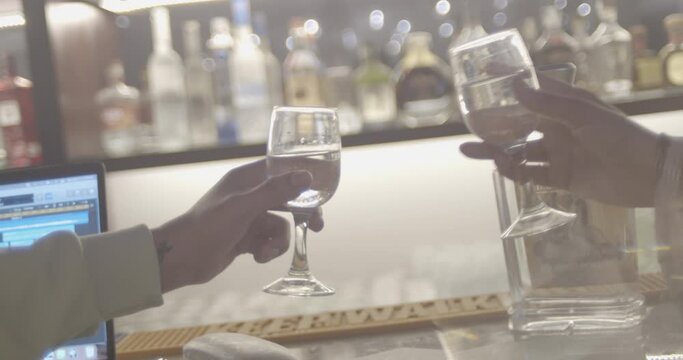 PAREJA EN BRINDIS CON COPAS DE CHAMPAGNE EN BAR