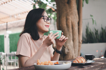 Young asian woman drinking coffee latte at a cafe
