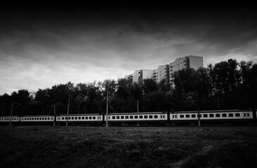 Black and white train is heading into autumn backdrop