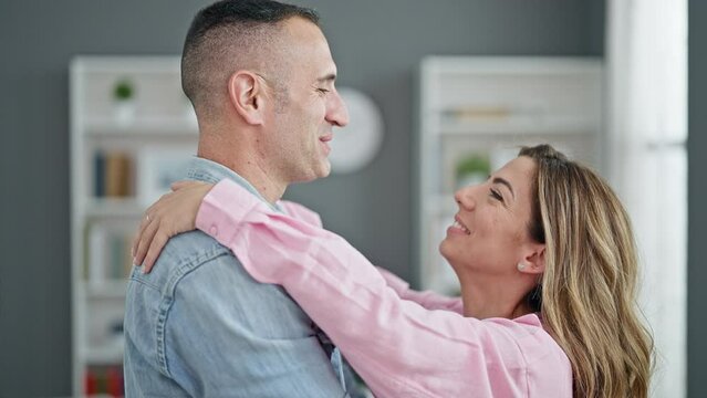 Man and woman couple hugging each other kissing at home