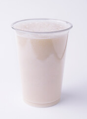 Vanilla milkshake covered with whipped cream in plastic glass