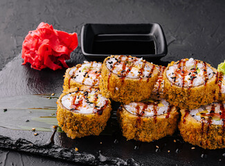 Warm sushi rolls with avocado on black