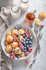 Homemade and delicious poffertjes with sweet fruits.