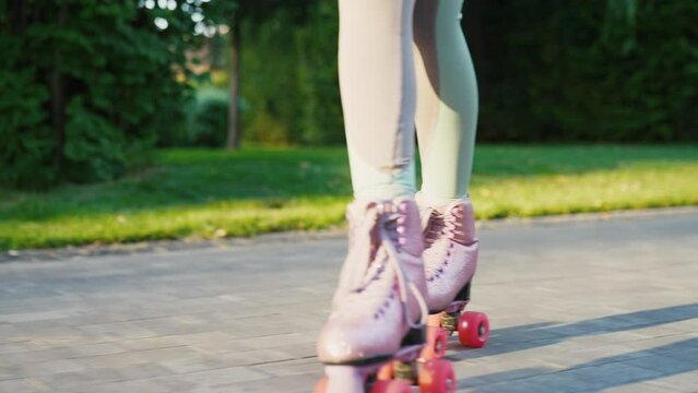 Close up shot of young woman riding quad rollers skates in city. Happy riding retro rollerskates