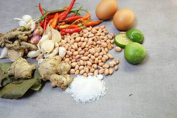 a collection of spices, chilies, onions, nuts and various kinds on a concrete background