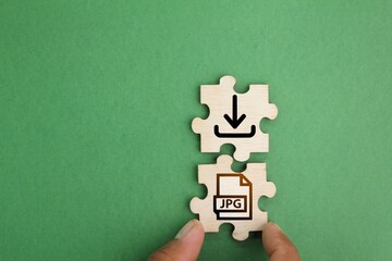 wooden puzzle with save jpeg file icon. the concept of saving a file or downloading a file in...