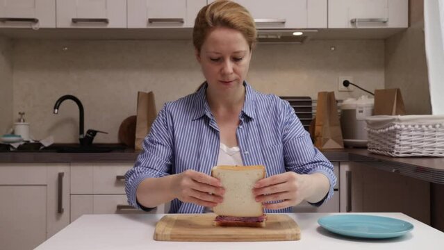 woman assembling a sandwich, combines bread with jam and peanut butter