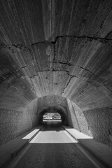 A concrete and stone tunnel under a highway