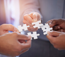Business people, hands and teamwork with puzzle collaboration for problem solving, growth and...