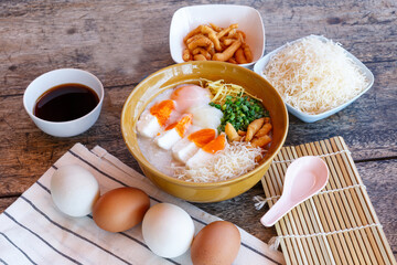 Congee, rice porridge with salted egg, Soft-boiled Egg leek, and ginger. Asian healthy meal, favorite breakfast for Southeast Asian people.