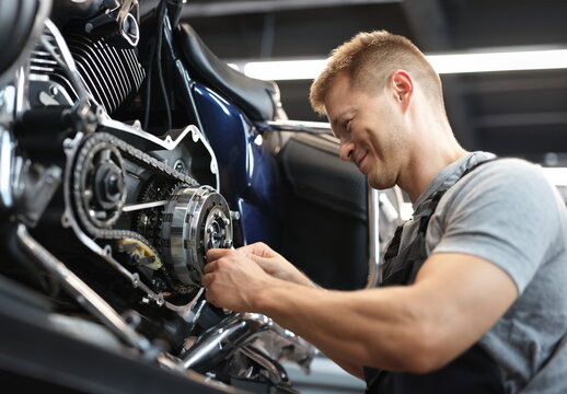 Male mechanik repair motorcycle in special service portrait. Education in field equipment repair concept