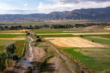 Paysage rural au Kirghizistan, avec les montagnes, des prairies et des cultures