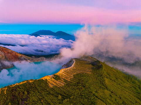 Aerial view Amazing of Mountains rock cliff at Kawah Ijen volcano with turquoise sulfur water lake at sunrise.Amazing nature landscape view at East Java, Indonesia. Natural landscape background