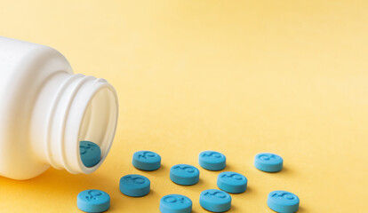 Blue pills with male gender symbol on a yellow background. Pills for men. Copy space for text