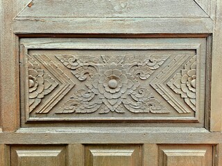 Wooden door with carved ornament close-up. Selective focus.