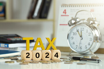 Tax and Vat Concept.Tax wooden letters on wooden cubes with 2024 on coins. income tax online return...