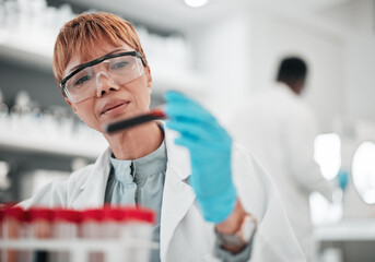 Woman, scientist and blood sample in lab, ideas and analysis with ppe glasses, safety and test. Science, pathology and expert with thinking, inspection and dna data for medical research in laboratory