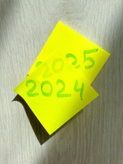 New Year 2024-2025 is written on yellow note paper on a light background. Business concept. Plans for the new year.