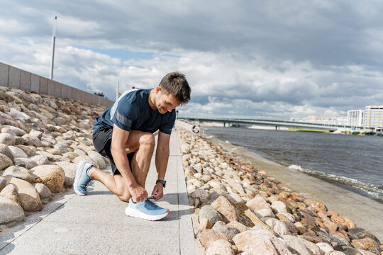 Male runner jogging in fitness clothes. Athlete by interval one workout. Sports man outdoor sports. Motivation and stimulation of fitness exercises.