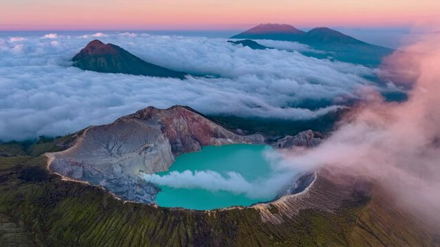 Aerial view flying to mountain Kawah Ijen wtih smoke coming out of volcano crater during sunrise, Java, Indonesia 