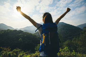 Cheering happy woman enjoying the view on morning mountain valley