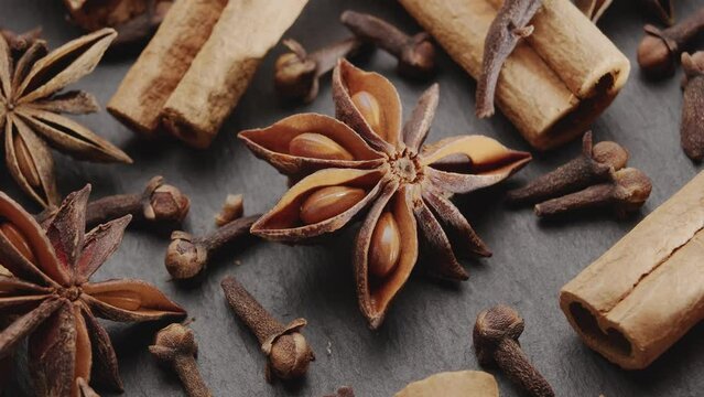 Lots of three spices for mulled wine &ndash; star anise, cinnamon and clove slowly scroll clockwise, macro video footage. A great background for your projects.