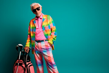 happy and extravagant old golf player man in his 80s holding a golf club