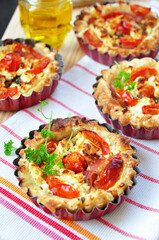 Gourmet Tomato and Feta Cheese Tarts on Striped Tablecloth: A Feast for the Eyes and the Palate - Perfect for Brunch, High Tea, or a Sumptuous Snack. Freshly Baked and Topped with Cherry Tomatoes