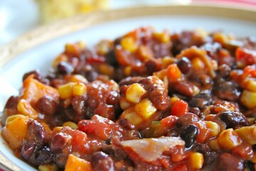 Colorful Medley: Close-Up of Black Bean and Corn Salsa in a White Plate with Gold Rim