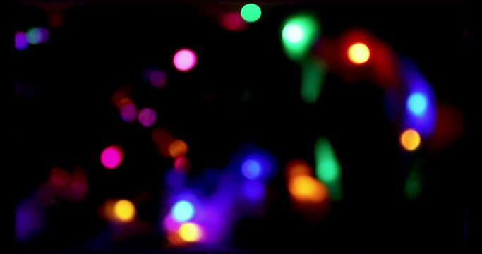 Multicolor, Blurry Lights on a Dark Background, Christmas or New Year Bokeh. Flashing Defocused Holiday Lights on a Dark Background.