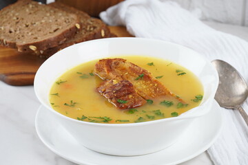 Pea soup with smoked pork ribs served in white bowl