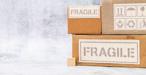 Wide shot of fragile boxes with wooden cube placed on marble surface.